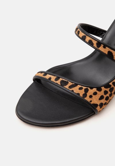 Sandale noire à bout ouvert avec deux fines lanières présentant un motif léopard marron et noir.