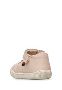 Light pink leather shoe with a high ankle, Velcro strap, cut-out details, and textured sole. Smooth finish with a rounded toe design.