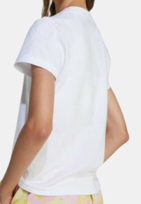 T-shirt bianca a maniche corte con scollatura rotonda e vestibilità rilassata, realizzata in morbido cotone, con dettagli di cucitura minimal.