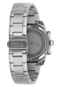 Montre en acier inoxydable argenté avec un bracelet à maillons, présentant un boîtier circulaire et un cadran rond simple avec la gravure "ACIER INOXYDABLE".