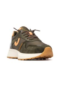 Zapatillas verde oliva con acentos naranjas, parte superior de gamuza y sintético, talón texturizado, punta redonda y una mediasuela de goma blanca con una suela de patrón.