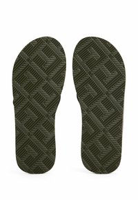 Soli in gomma verde per infradito con una superficie strutturata e decorata da un design a diamante per una maggiore aderenza e durata.