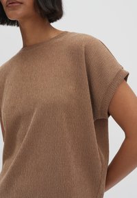 Top corto a maniche corte di colore marrone, con scollatura rotonda. Il materiale presenta un leggero motivo a pieghe, creando una vestibilità morbida e rilassata.