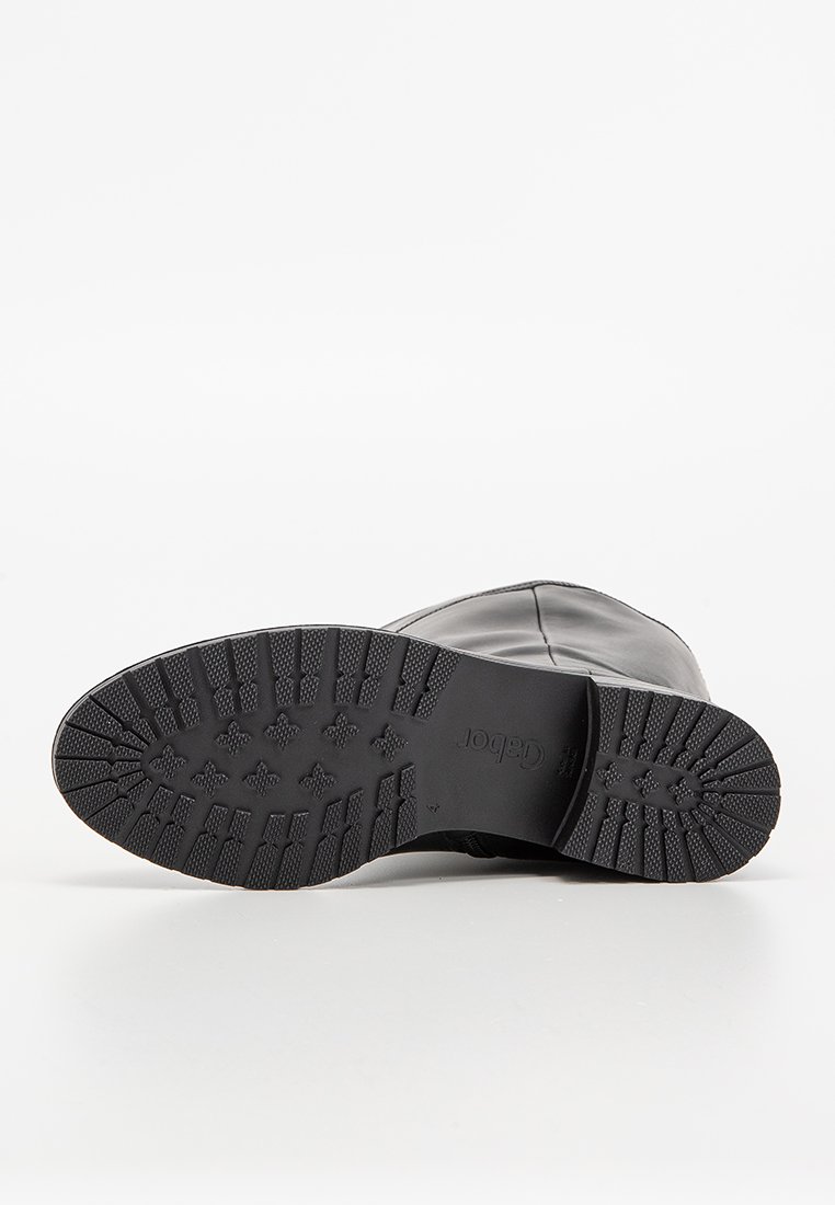 Schwarze Lederstiefel mit einer strukturierten Gummisohle, die ein glattes Oberdesign und eine abgerundete Zehenpartie aufweist. Die Sohle hat Trittmuster für einen guten Halt.