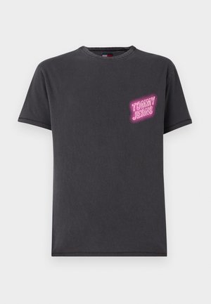 Black cotton t-shirt featuring a round neck, short sleeves, and a front left chest print reading "TOMMY JEANS" in pink neon style.
