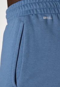 Light blue athletic shorts made of textured fabric, featuring a drawstring waistband and side pockets with the 'DRYCELL' logo on the front.