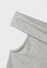 Grå bomullsplagg med enkelt design, med bred halsutskjæring og én erme. Glatt tekstur med subtil melert mønster.