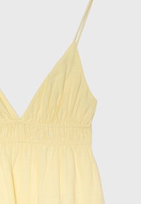 Robe jaune sans manches avec fines bretelles doubles, encolure en V et taille élastique froncée.