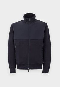 Marineblå zip-op jakke med høj krave, lavet af blødt materiale, med et ensfarvet øverste panel og to sidelommer med lynlås.