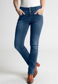 Tamsiai mėlynos džinsinės kelnės su siauru siluetu, turinčios dvi priekines kišenes, penkių mygtukų užsegimą ir subtilius siuvinėjimo akcentus.