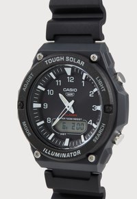Montre Casio Tough Solar avec un cadran analogique-numérique noir, un bracelet en caoutchouc, des accents argentés et des fonctionnalités telles que la résistance à l'eau et les réglages d'alarme.