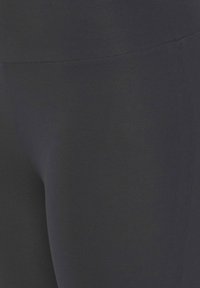 Black leggings, made of smooth, stretchy fabric with a subtle ribbed texture. No visible patterns or accents. Standard design and fit.
