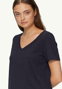 Marineblauwe V-hals t-shirt met korte mouwen; zachte, gladde textuur; ontspannen pasvorm; eenvoudig ontwerp zonder patronen of extra hardware.