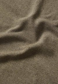 Gros plan sur un tissu brun froissé à texture avec un motif de tissage serré.