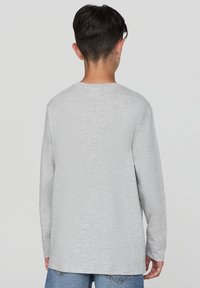 Szara koszulka z długim rękawem wykonana z mieszanki bawełny, z okrągłym dekoltem i luźnym krojem. Miękka faktura, minimalistyczny design.