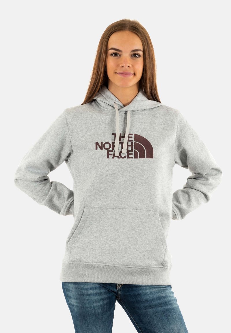 Felpa grigia con cappuccio realizzata in tessuto, dotata di una tasca frontale, con il logo marrone scuro di "The North Face" e lacci sul cappuccio.