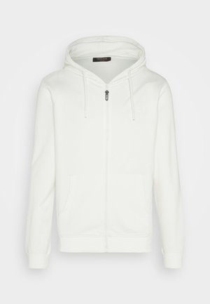 White zip-up hoodie made of soft fabric, featuring a drawstring hood, two front pockets, and a small logo on the chest.