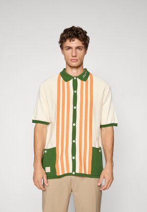 Short-sleeve knit shirt featuring green trim, vertical orange and cream stripes, buttons down the front, and two green pockets at the bottom.