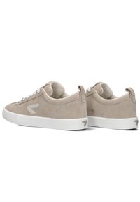 Beige suède sneakers met een witte rubberen zool, voorzien van tonale stiksels, een ronde neus en een logo-accent aan de zijkant en achterkant van de hak.