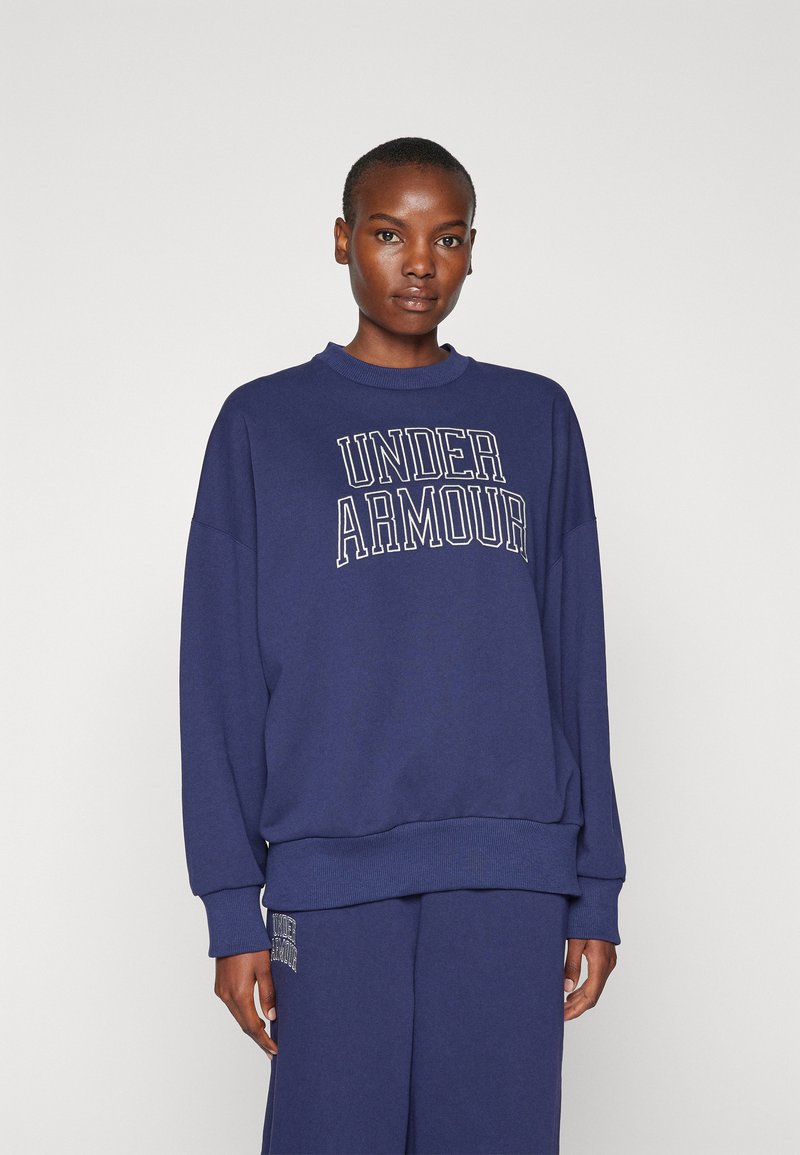 Mørkeblå sweatshirt lavet af bomuldsblanding med ribbet krave og manchetter. Har "Under Armour" logo i fed hvid skrift.