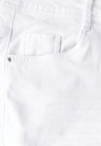 Vit denim tyg har en framficka med en liten silvernagel, en ren design och en subtil textur.