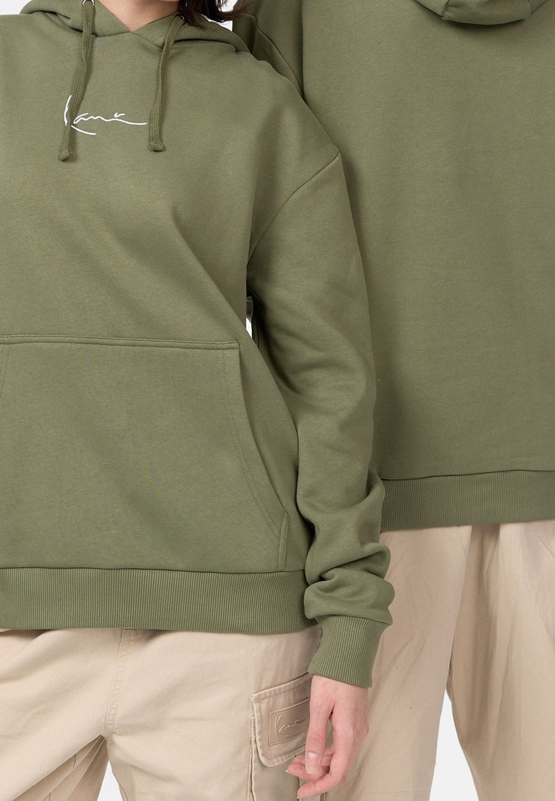 Olivgrön huvtröja i bomullsblandning, med en framficka och ribbade muddkanter, med broderad logotypdetalj på bröstet.