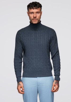 Tyrkysový rolák vyrobený z texturovaného pleteného materiálu s kabelkovým vzorem, doplněný o světle modré kalhoty. Jemný branding na lemu.