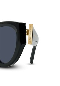 Černé oversized sluneční brýle s tmavými skly, silným plastovým rámem a zlatými kovovými akcenty na spáncích s vyrytým logem.