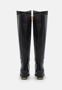 Botas de cuero negro hasta la rodilla con un acabado suave, detalles de costura vertical, doble cremallera dorada en la parte posterior y tacón cuadrado con acento de cadena.