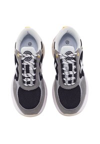 Zapatillas deportivas con parte superior de malla gris y negra, cordones blancos, suela acolchada y acento amarillo cerca del talón. Logotipo redondo en la lengüeta.