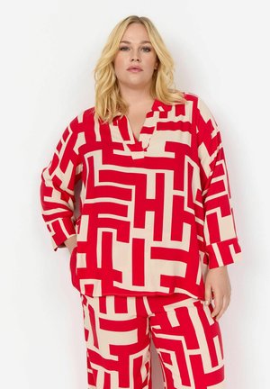 Rote und beigefarbene gemusterte Bluse mit lässiger Passform, V-Ausschnitt und langen Ärmeln, kombiniert mit passenden Hosen. Glattes Material.