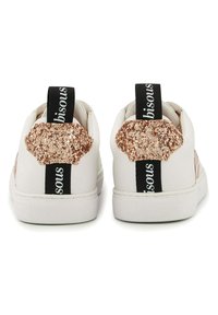 Baskets blanches avec une finition texturée, dotées d'une accent doré rose pailleté au niveau du talon et d'une marque noire sur la languette.