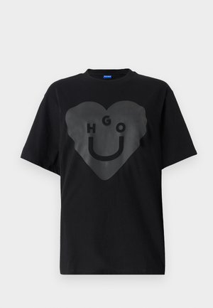 Zwarte t-shirt, oversized pasvorm, met een grote hartgrafiek met de tekst "HGO" en een smiley gezicht in een glanzende afwerking op de voorkant.