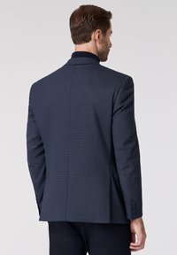 Navyblauer Blazer aus strukturiertem Stoff, mit Reverskragen und Drei-Knopf-Manschetten. Bietet eine taillierte Passform und einen Schlitzausschnitt hinten.