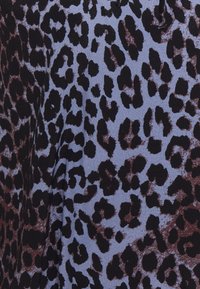 Leopardenmusterstoff in Schwarz- und Brauntönen auf einem hellblauen Hintergrund, der unterschiedliche Fleckgrößen und unregelmäßige Formen zeigt.