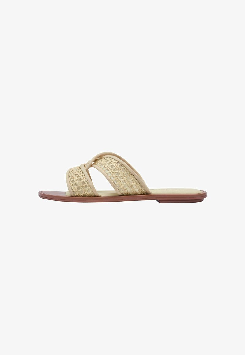Sandale plate à brides tissées beige et semelle marron, conçue pour une tenue décontractée.