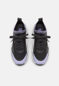 Baskets de sport noires et violettes avec tissu en mesh, lacets noirs texturés et semelle argentée brillante ; présente un col violet côtelé.