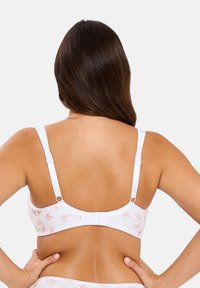 Soutien-gorge blanc en tissu doux, avec des motifs floraux rose clair, des bretelles réglables et une fermeture à crochet au dos.