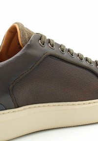 Sneaker in pelle marrone con pannello in tessuto testurizzato, punta rotonda, lacci verde oliva e suola in gomma beige. Caratterizzato da un design perforato sul lato.