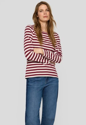 Long-sleeve striped shirt in maroon and cream, made of soft fabric. Features a round neckline and a relaxed fit, paired with blue jeans.