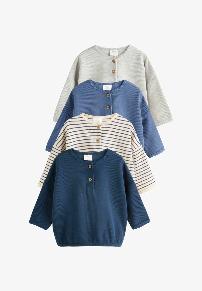 Cuatro camisetas de bebé de manga larga con botones de madera en gris, azul, crema con rayas azul marino y azul oscuro, dispuestas superpuestas sobre un fondo blanco.