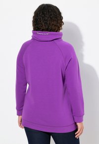Felpa viola con colletto alto, polsini a costine e dettaglio con coulisse. Materiale morbido e vestibilità morbida, caratterizzata da una linea dell'orlo dritta.