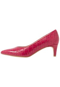 Talons en cuir synthétique de crocodile rose avec un bout pointu et un petit talon carré, présentant une surface texturée et une doublure intérieure lisse.