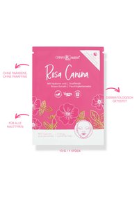 Verpackung eines rosa Gesichtsmaske mit weißen Blumenillustrationen, Produktname "Rosa Canina" und wichtigen Eigenschaften in sowohl deutscher als auch englischer Sprache.