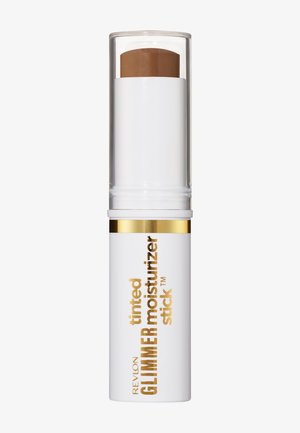 Revlon Glimmer getinte moisturizer stick in lichtbruine kleur, witte tube met gouden accenten en doorzichtige dop.