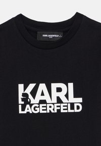 Μαύρο βαμβακερό μπλουζάκι με μεγάλο λευκό λογότυπο «KARL LAGERFELD». Στρογγυλεμένος λαιμός με απαλό υλικό, κατάλληλο για παιδιά.