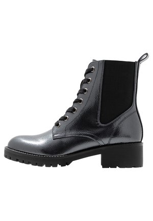 Bottes noires à la cheville avec une finition en cuir brillant, à lacets, panneau latéral élastique et talon bloc. Tige texturée et semelle extérieure robuste.