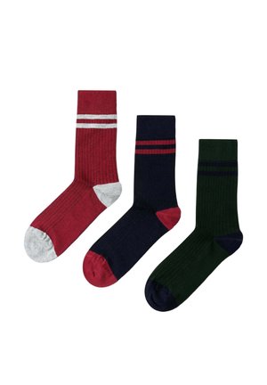 Tres calcetines de caña media con canalé: uno rojo con talón/punta gris y rayas blancas, uno azul marino con talón/punta roja y rayas, uno verde con talón/punta azul marino y rayas.