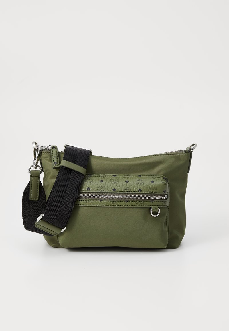 Zaļa neilona plecu soma ar priekšējo rāvējslēdzēja kabatu, strukturētu rakstu, regulējamu melnu siksnu un sudraba aksesuāriem.