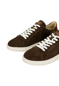 Paar braune Wildledersneaker mit weißen Schnürsenkeln und Gummisohlen, Seiten- und Draufsicht auf weißem Hintergrund.